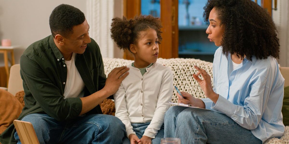 A Family Centered Treatment Practitioner speaks to a father and his daughter
