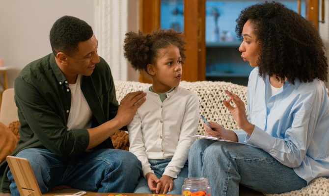 A Family Centered Treatment Practitioner speaks to a father and his daughter