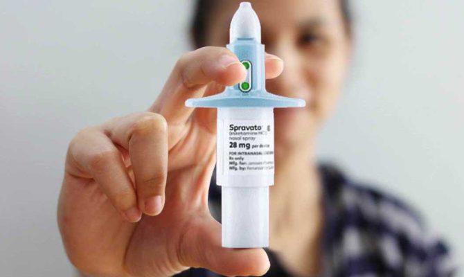 A woman holds the Spravato nasal spray treatment.