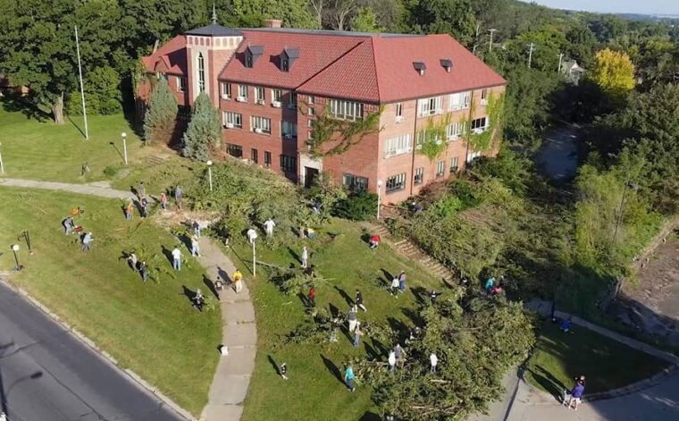 Volunteers clear out trees and overgrown brush on the site of the Dana College Administration building in Blair, NE.